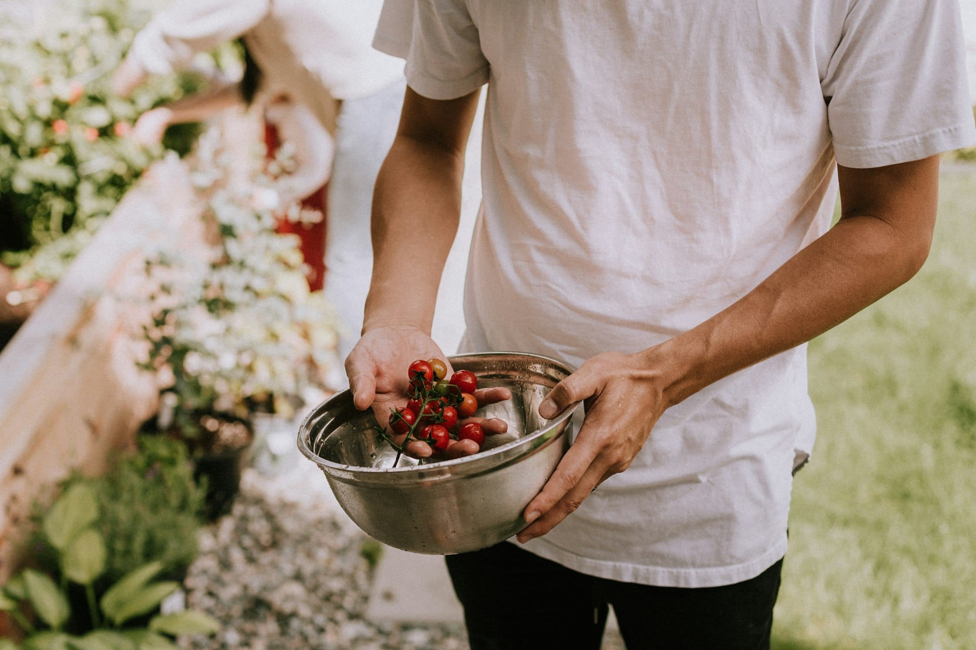 A maker holding fresh cherries at a farmers market stall